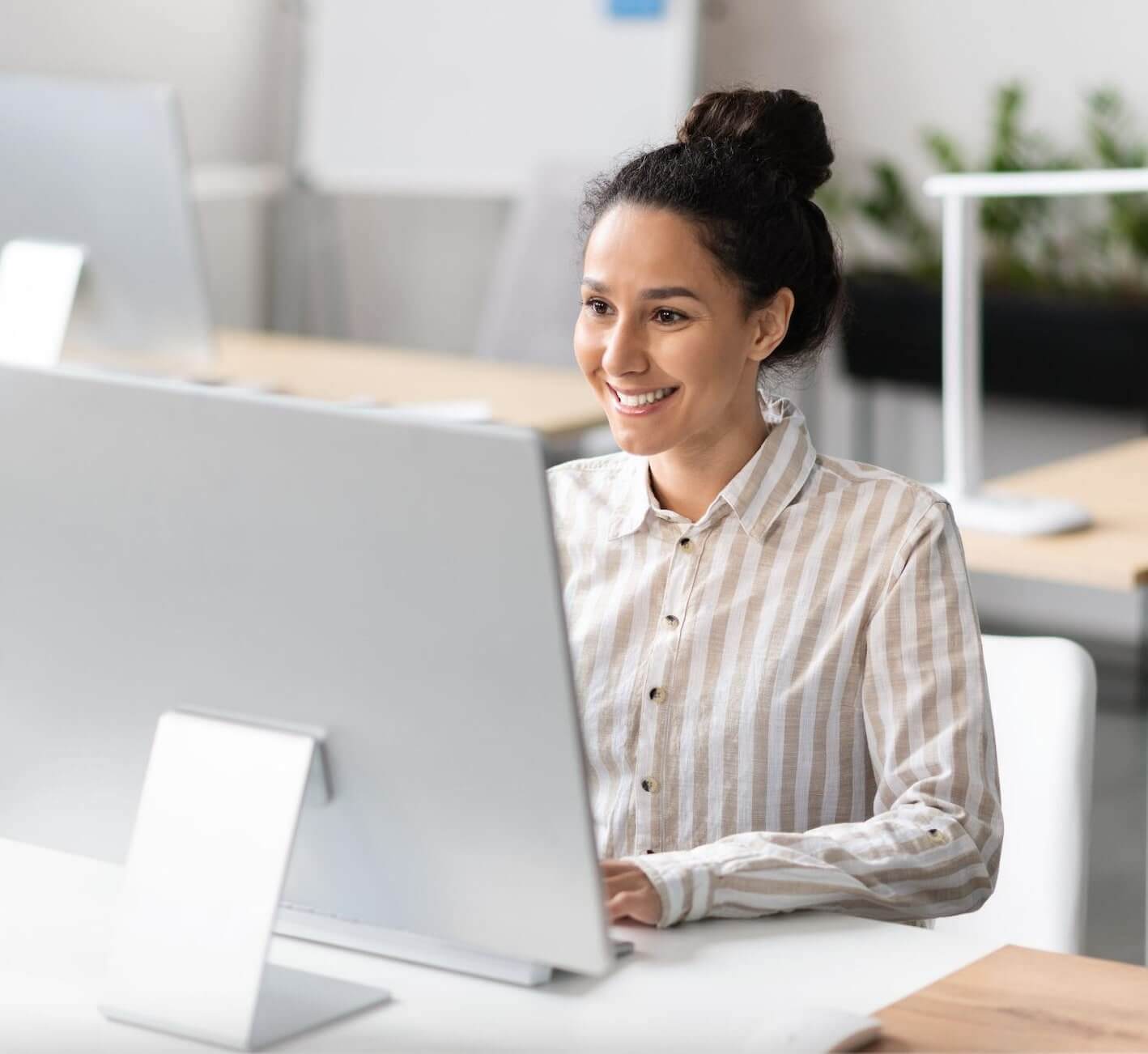An employee smiling at a Desktop
